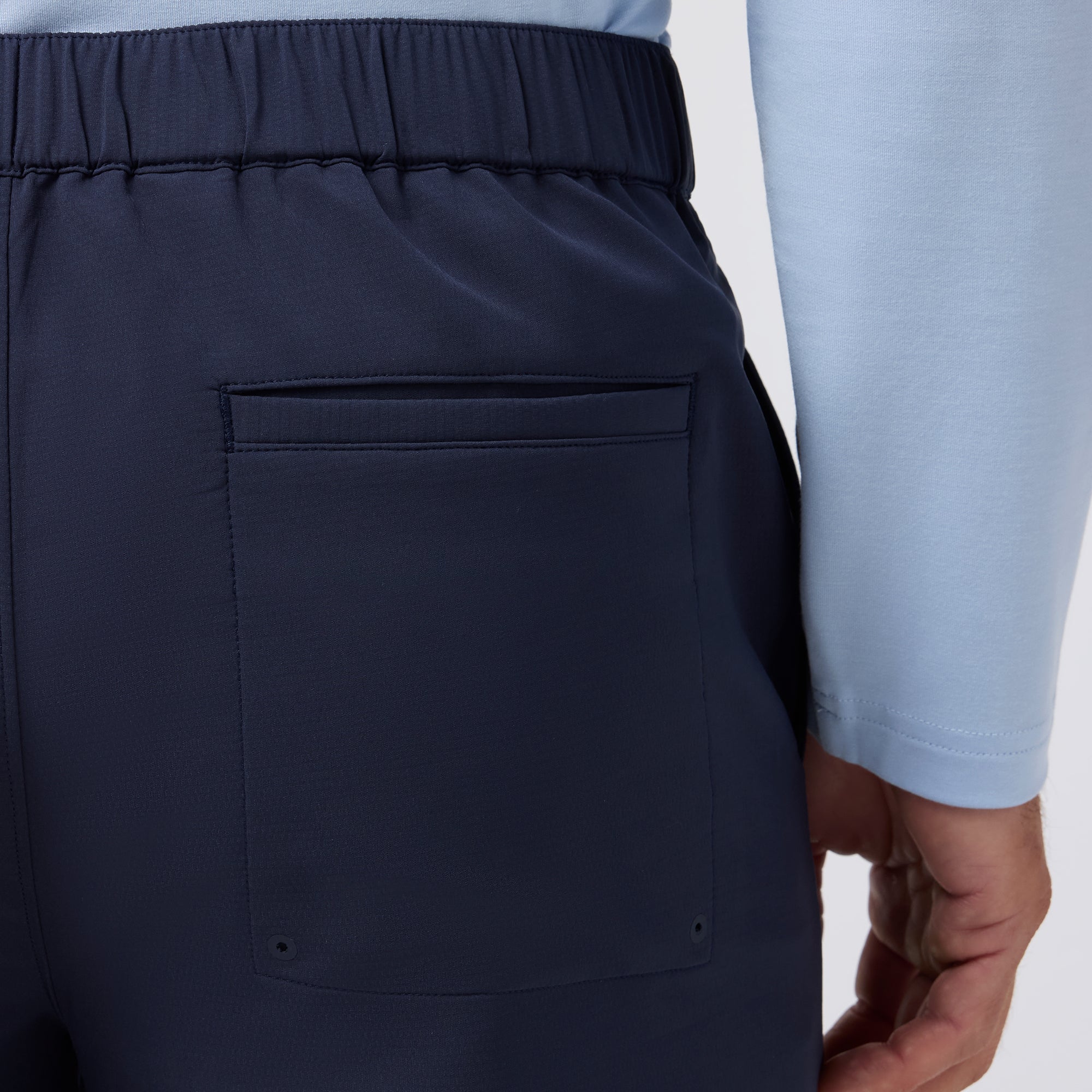 Navy blue pants with a pocket on a light gray background