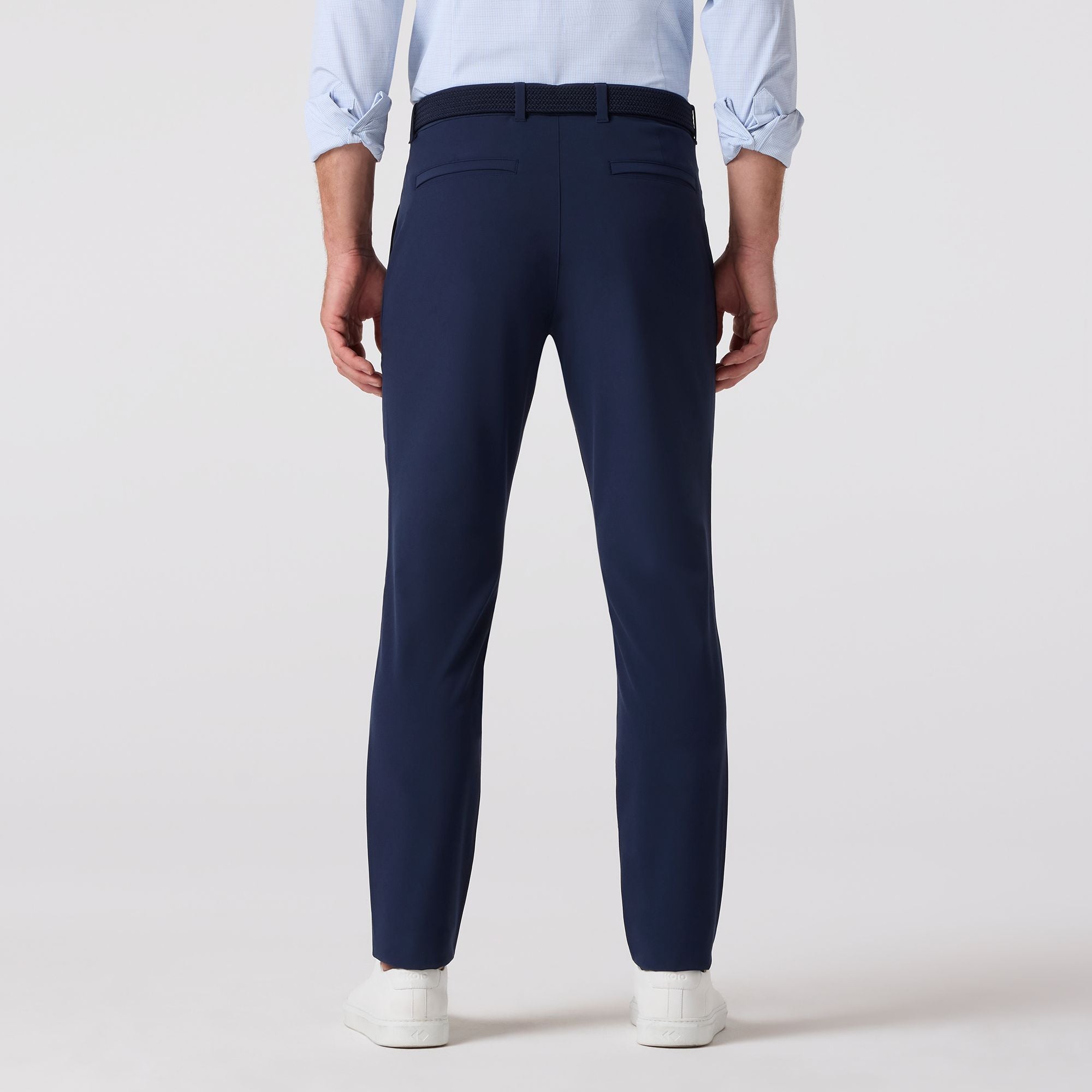 Person wearing navy pants with a plain background