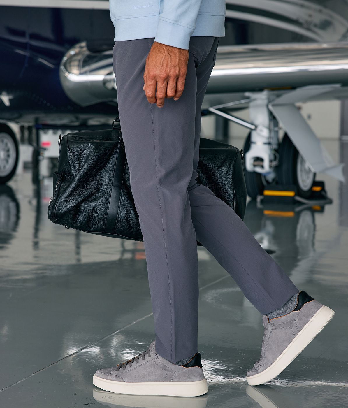 Man outside wearing the Charcoal Solid Helmsman 5 Pocket Pant.