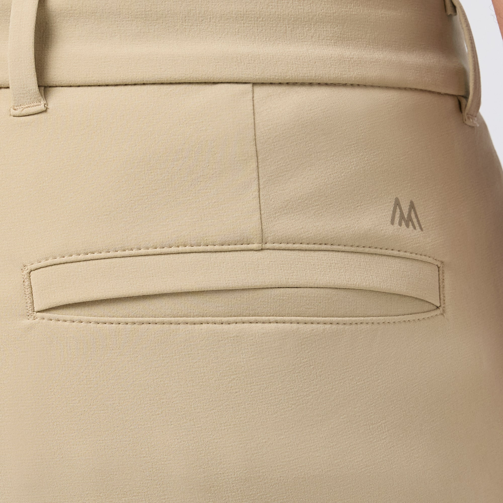 Beige pants with a Mizzen+Main logo on a white background