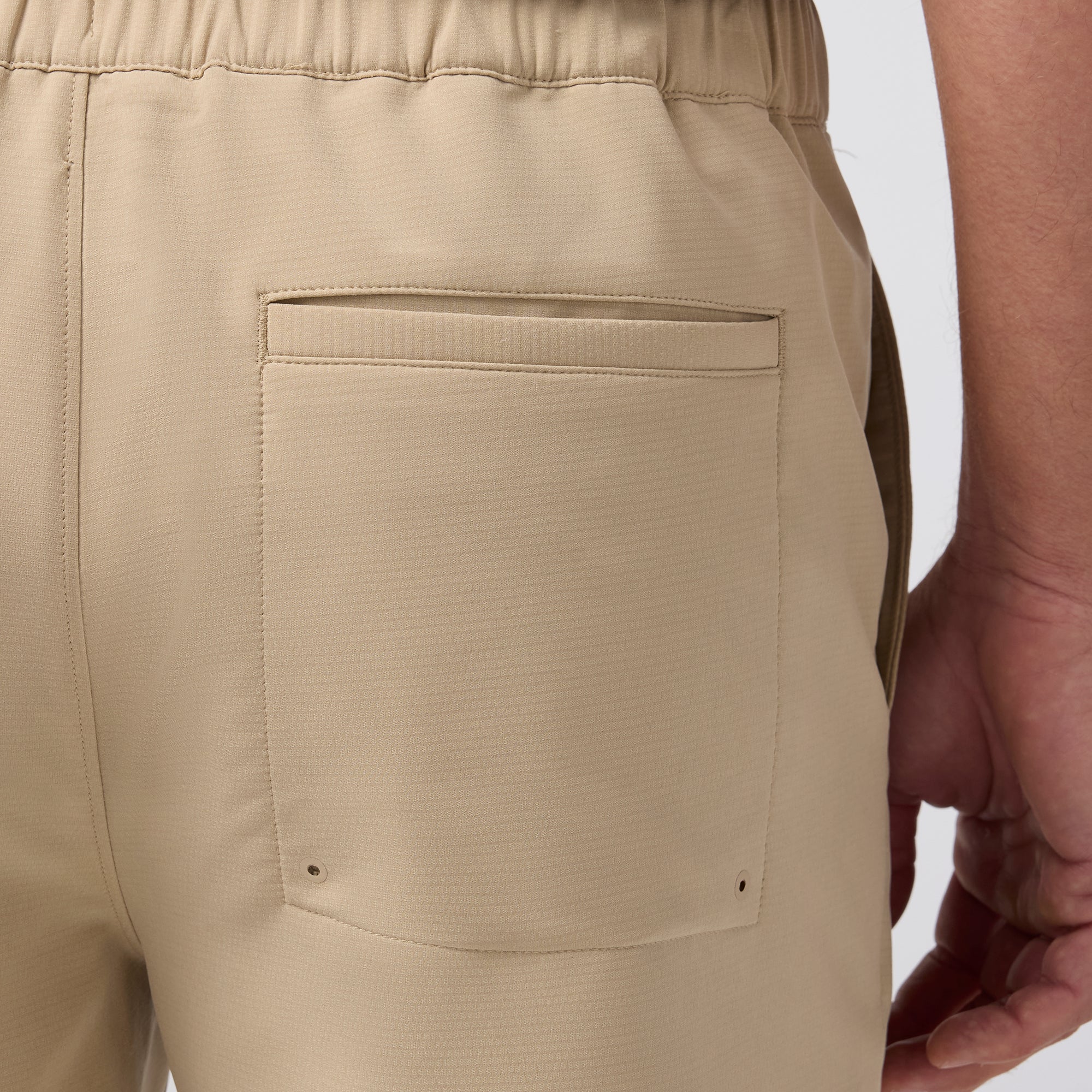 Close-up of beige shorts with a pocket on a white background