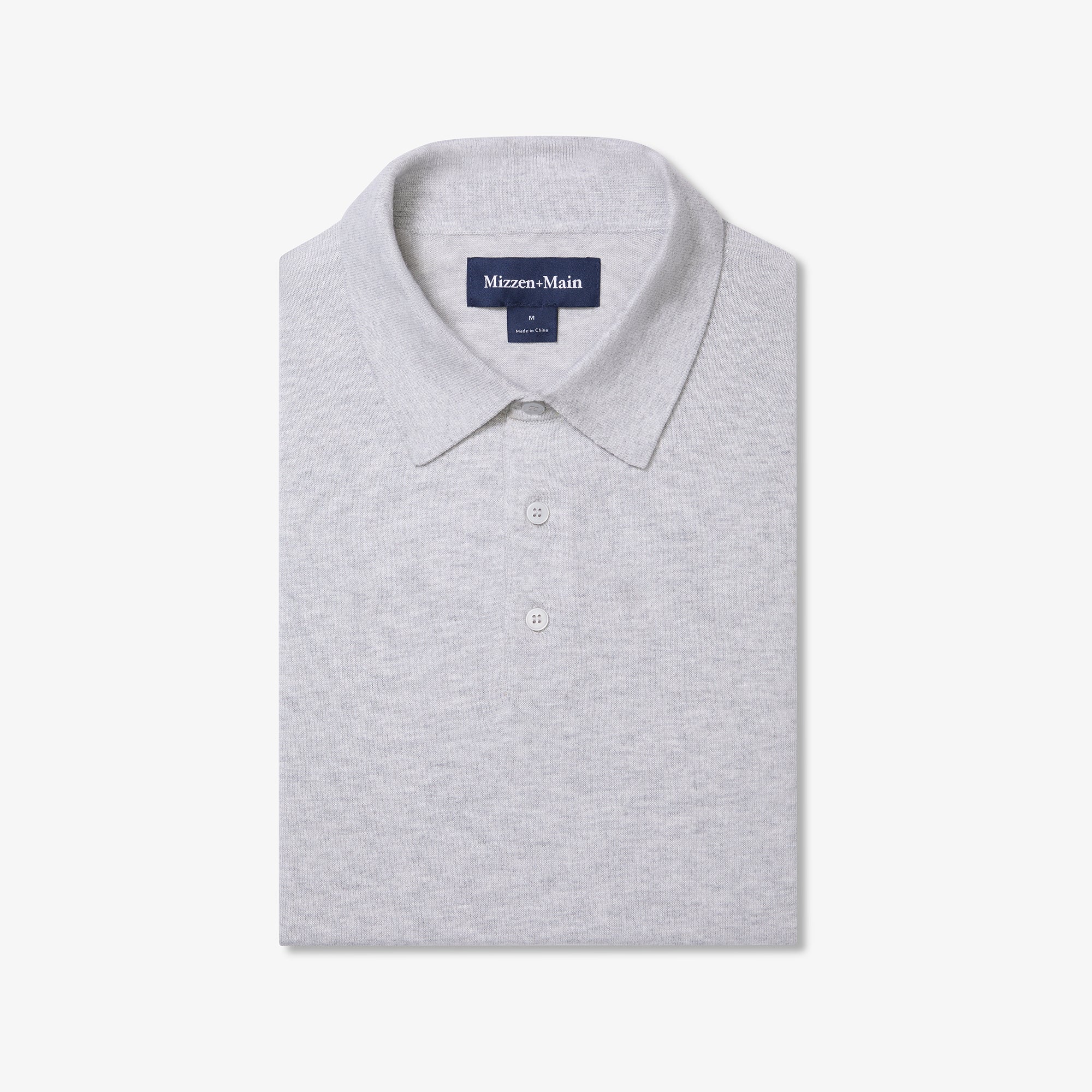 Folded gray polo shirt with 'Mizzen+Main' label on a white background