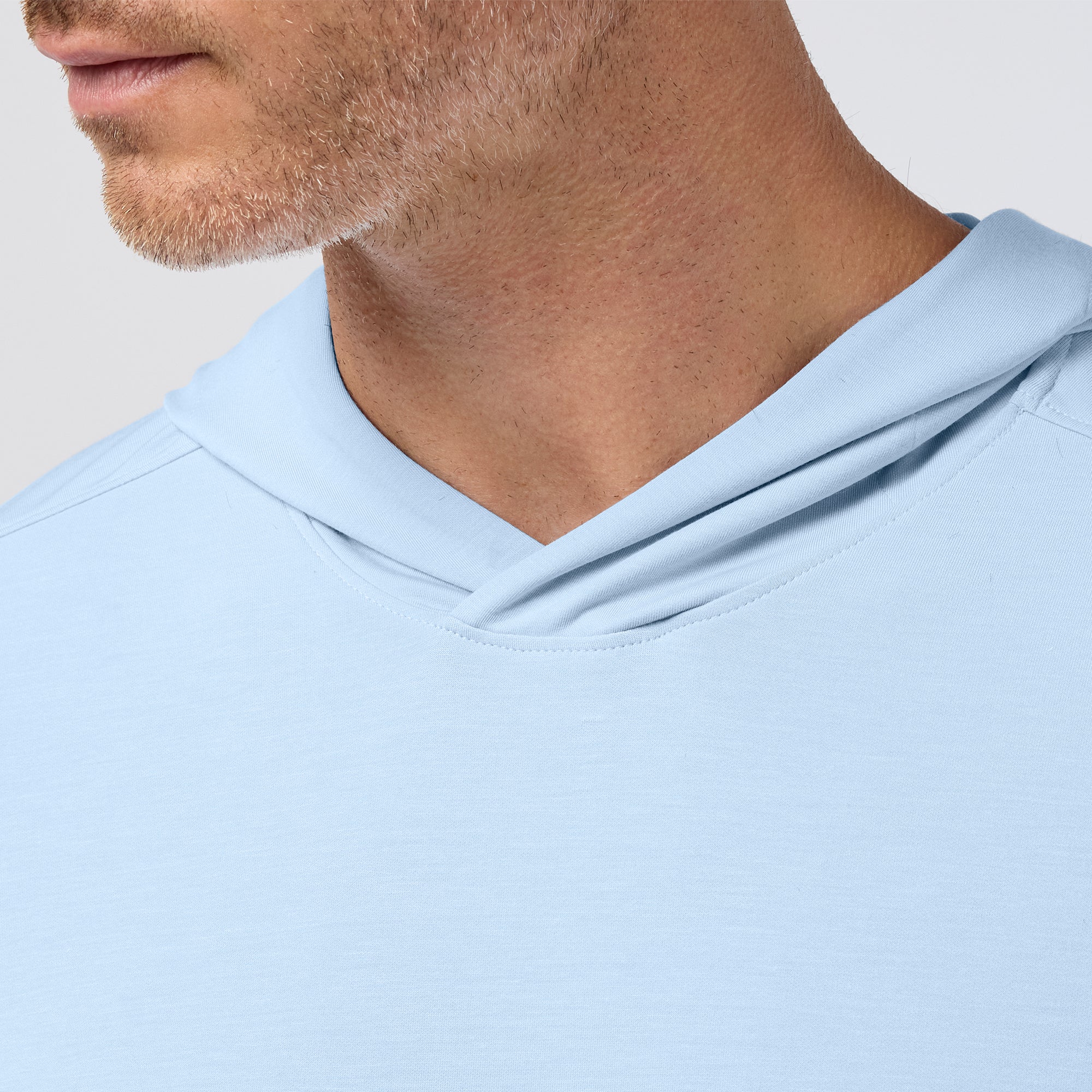 Light blue hoodie worn by a person with a neutral background